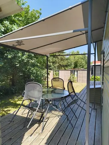 Terras met tafel en stoelen onder de luifel