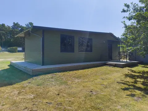 Zijkant van het chalet in het gras