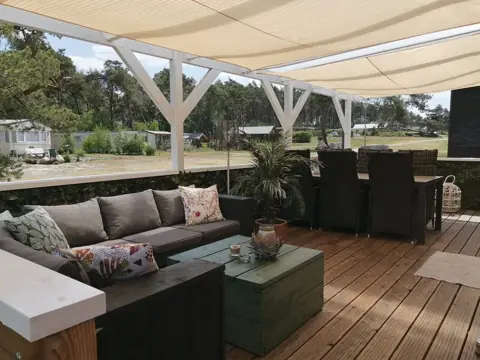 Overdekt terras met loungeset en eettafel