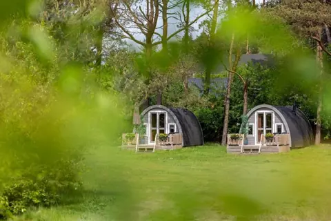 Twee houten pods tussen het groen